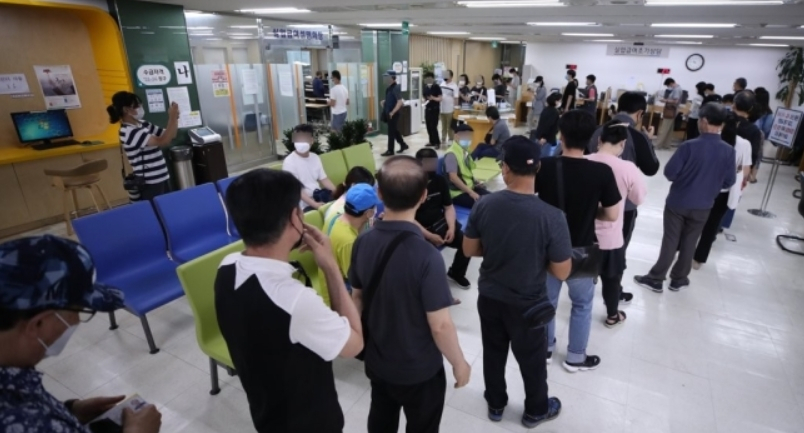 코로나19 사태 장기화로 고용한파가 지속되고 있는 가운데 실업자들이 실업급여 설명회장에 입장하기 위해 길게 줄을 서 있다. [연합]