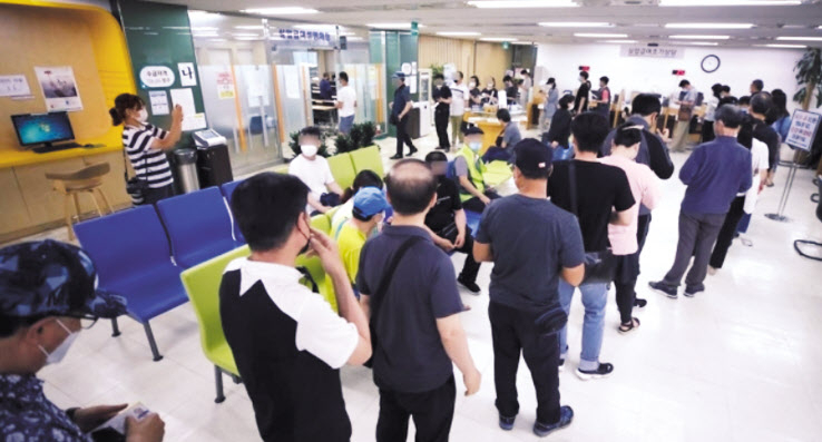 코로나19 사태 장기화로 고용한파가 지속되고 있는 가운데 실업자들이 실업급여 설명회장에 입장하기 위해 길게 줄을 서 있다. [연합]