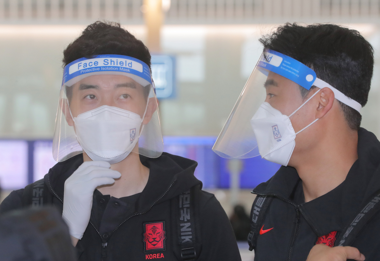 일본과의 친선경기에 나서는 축구대표팀 조현우 등 선수단이 페이스쉴드와 마스크 등을 착용한 채 22일 오전 인천국제공항을 통해 출국하고 있다. [연합]