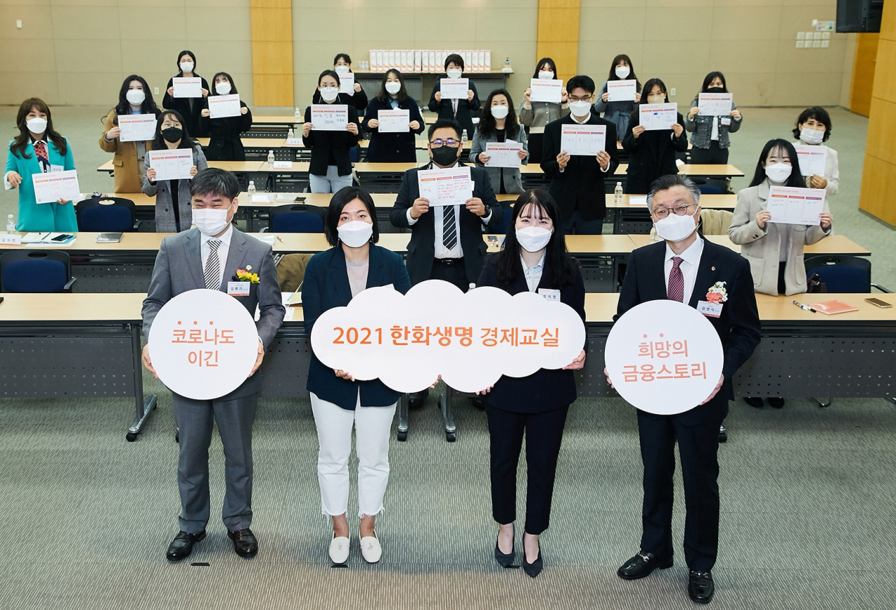 한화생명이 22일 서울 여의도 63빌딩에서 ‘2021 한화생명 경제교실’ 출범식을 실시했다. 김영식 한화생명 홍보실장 (오른쪽 첫번째)과 김병기 사회복지법인 아이들과미래재단의 사업본부장(왼쪽 첫번째)이 출범식에 참석한 강사들과 기념촬영을 하고 있다. [한화생명 제공]