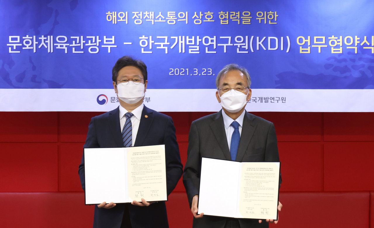 황희(왼쪽) 문화체육관광부 장관이 23일 세종시 정부세종청사 15동 문체부 대회의실에서 열린 해외 정책소통의 상호 협력을 위한 문화체육관광부와 한국개발연구원(KDI)의 업무협약식에서 최정표 한국개발연구원장과 협약서에 서명하고 기념촬영을 하고 있다. [문체부 제공]