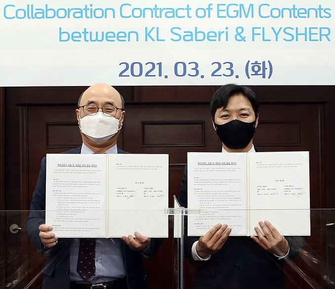 강원랜드 문태곤(왼쪽) 대표와 소셜카지노 ㈜플라이셔 이필주 대표가 협약서에 서명한뒤 인증샷을 찍고 있다.