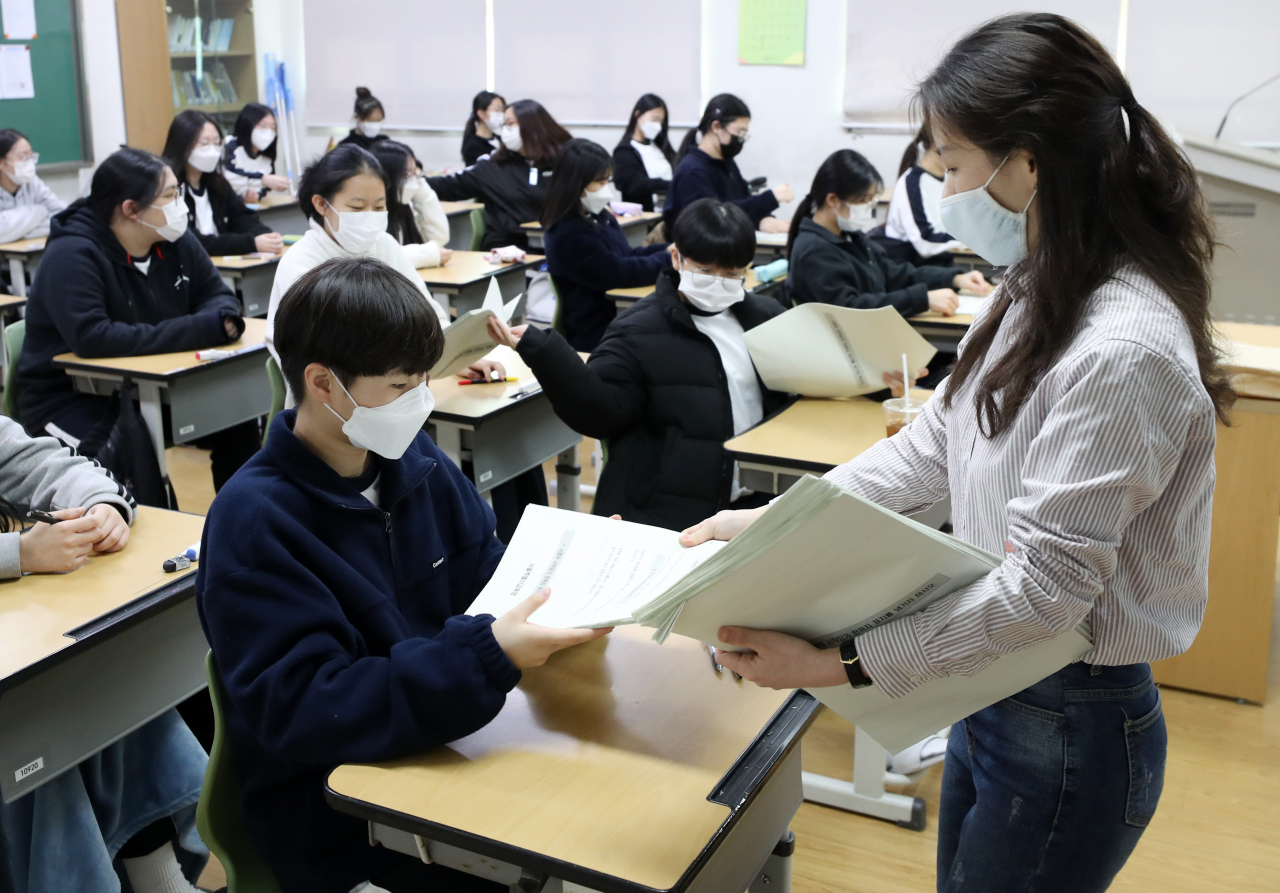 2021학년도 3월 전국연합학력평가(학평)가 치러지는 지난 23일 강원 춘천시 춘천여자고등학교 1학년 교실에서 학생들이 교사로부터 시험지를 건네받고 있다. 이번 학평은 교내 밀집도를 줄여 코로나19 확산을 막고자 이날 고교 1학년생을 시작으로 24일 고교 2년생, 25일 고교 3년생 차례로 사흘간 진행된다. [연합]