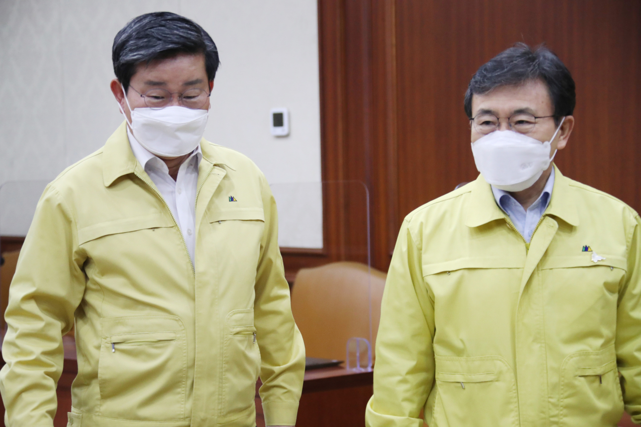 전해철 행안부 장관(왼쪽)과 권덕철 보건복지부 장관(오른쪽)이 24일 정부서울청사에서 열린 코로나19 대응 중앙재난안전대책본부 회의에 참석하고 있다. ［연합］