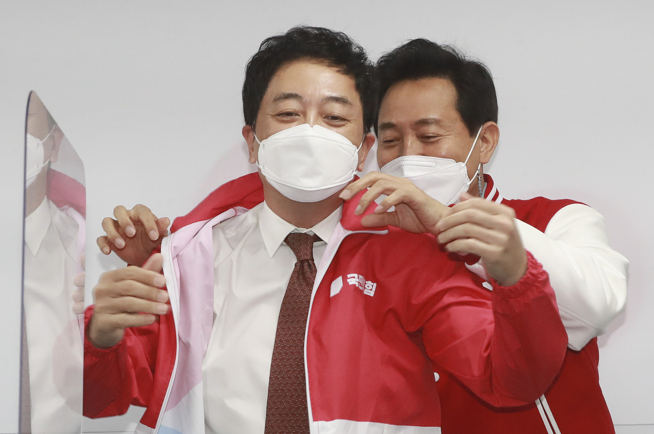 국민의힘 오세훈 서울시장 후보가 24일 오전 서울 여의도 중앙당사에서 열린 선거대책위원회 회의에서 금태섭 공동선거대책위원장에게 당 점퍼를 입혀주고 있다. [연합]