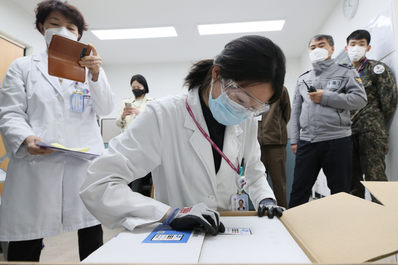 지난 24일 오전 서울 중구 국립중앙의료원 중앙예방접종센터에서 약사가 이날 도착한 화이자 코로나19 백신의 온도 기록 장치를 끄고 있다. [연합]