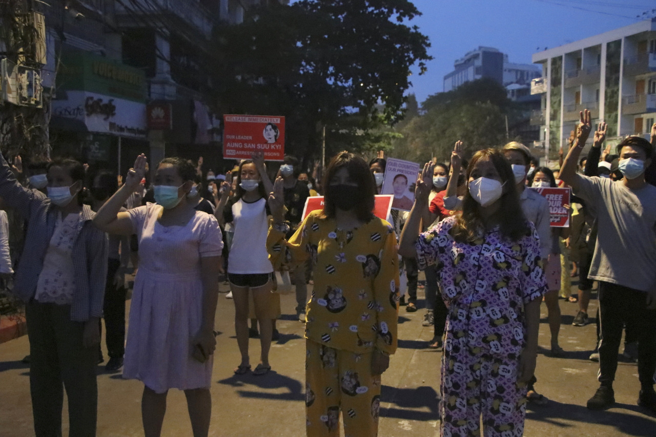 지난 22일 미얀마 양곤에서 반쿠데타 시위대가 저항운동의 상징인 세 손가락 경례를 하고 있다. [AP]