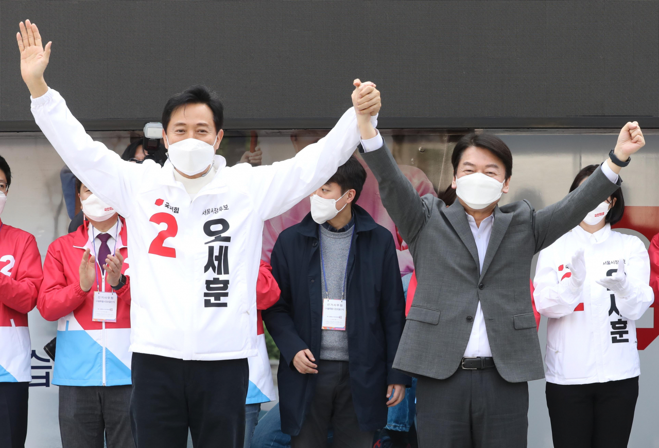4·7 재보선 오세훈 국민의힘 서울시장 후보와 안철수 공동선대위원장이 25일 오후 서울 덕수궁 대한문 앞에서 열린 유세에서 손을 맞잡아 들고 지지지들에게 인사하고 있다. [국회사진기자단]
