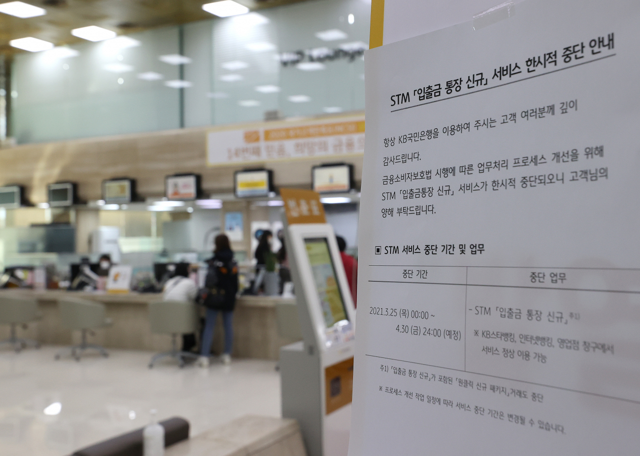 금융소비자보호법(금소법) 시행 첫 날인 25일 오후 서울 KB국민은행 여의도본점에 STM(스마트 텔러 머신) 입출금 통장 신규 서비스의 한시적 중단 관련 안내문이 붙어있다.[연합]