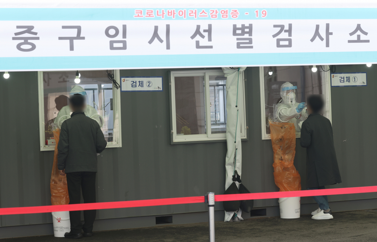 26일 서울역 광장 중구 임시선별검사소에서 의료진이 신종 코로나바이러스 감염증(코로나19) 검사를 시행하고 있다. 정부는 이날 '코로나19 대응' 중앙재난안전대책본부 회의에서 다음 주부터 2주 동안 지금의 사회적 거리두기 단계 및 5인 이상 모임금지 지침을 그대로 유지하기로 결정했다. 연합뉴스