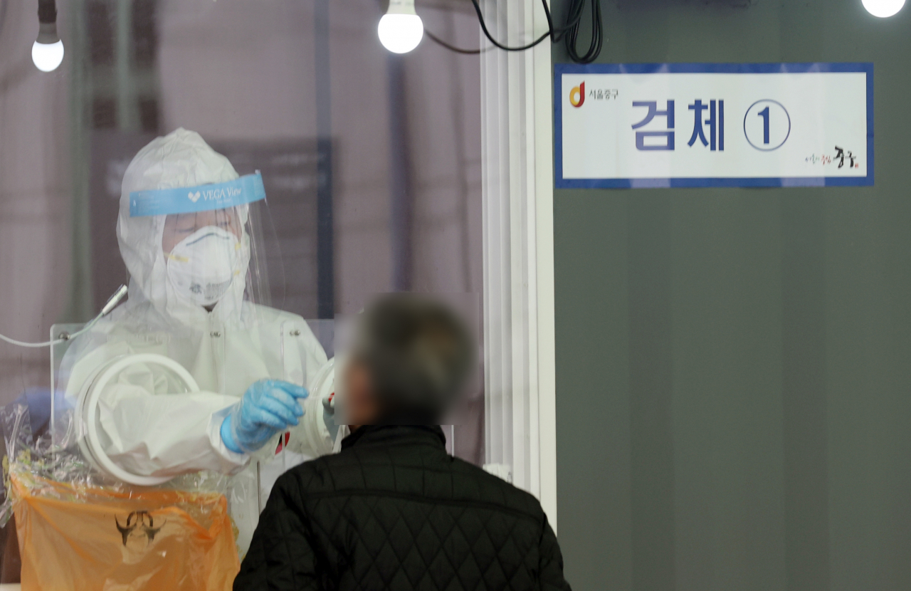 26일 서울역 광장 중구 임시선별검사소에서 의료진이 코로나19 검사를 시행하고 있다. 정부는 이날 '코로나19 대응' 중앙재난안전대책본부 회의에서 다음주부터 2주 동안 지금의 사회적 거리두기 단계(수도권 2단계, 비수도권 1.5단계) 및 5인 이상 모임금지 지침을 그대로 유지하기로 결정했다. [연합]