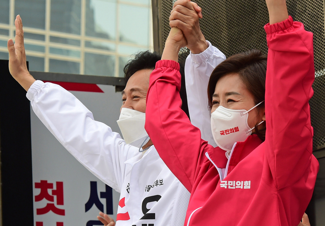 오세훈 국민의힘 4·7 재보선 서울시장 후보가 지난 25일 오후 서울 덕수궁 대한문 앞에서 열린 유세에서 나경원 전 의원과 손을 맞잡아 들고 인사하고 있다. [연합]