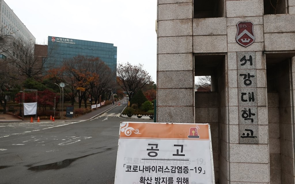 지난해 11월 22일 코로나19 확진자 발생으로 임시 폐쇄, 비대면 수업 전환 조치가 취해진 서강대학교 정문에 출입 통제를 알리는 현수막이 붙어 있다. [연합]