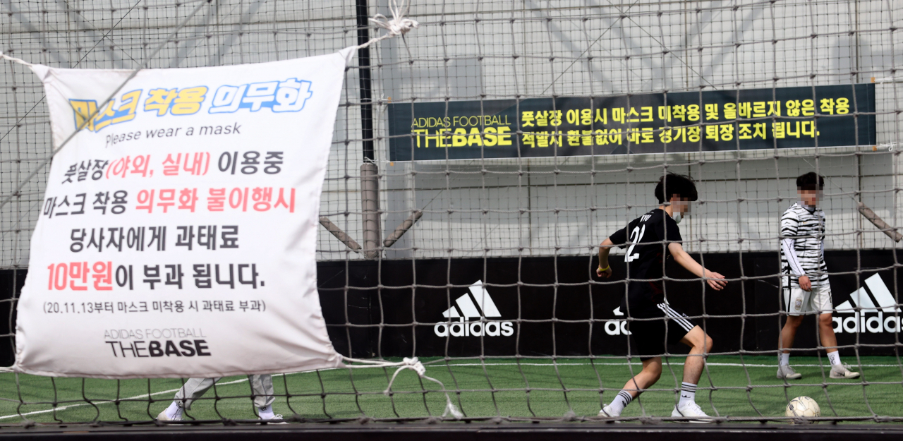 정부가 다음 주부터 2주 동안 사회적 거리두기 단계 및 5인 이상 모임금지 지침을 유지한다고 밝힌 가운데 서울 용산구의 한 야외 풋살장을 찾은 시민들이 풋살을 즐기고 있다. 이날 정부 발표에 따라 기존 거리두기 2단계에서 적용을 받았던 영화관·실내체육시설 등 외에도 실외체육시설, 스포츠경기장, 이미용업, 카지노, 경륜·경정·경마장, 미술관·박물관, 도서관, 전시회·박람회, 마사지업·안마소 등에서 음식물 섭취가 불가능해진다. [연합]