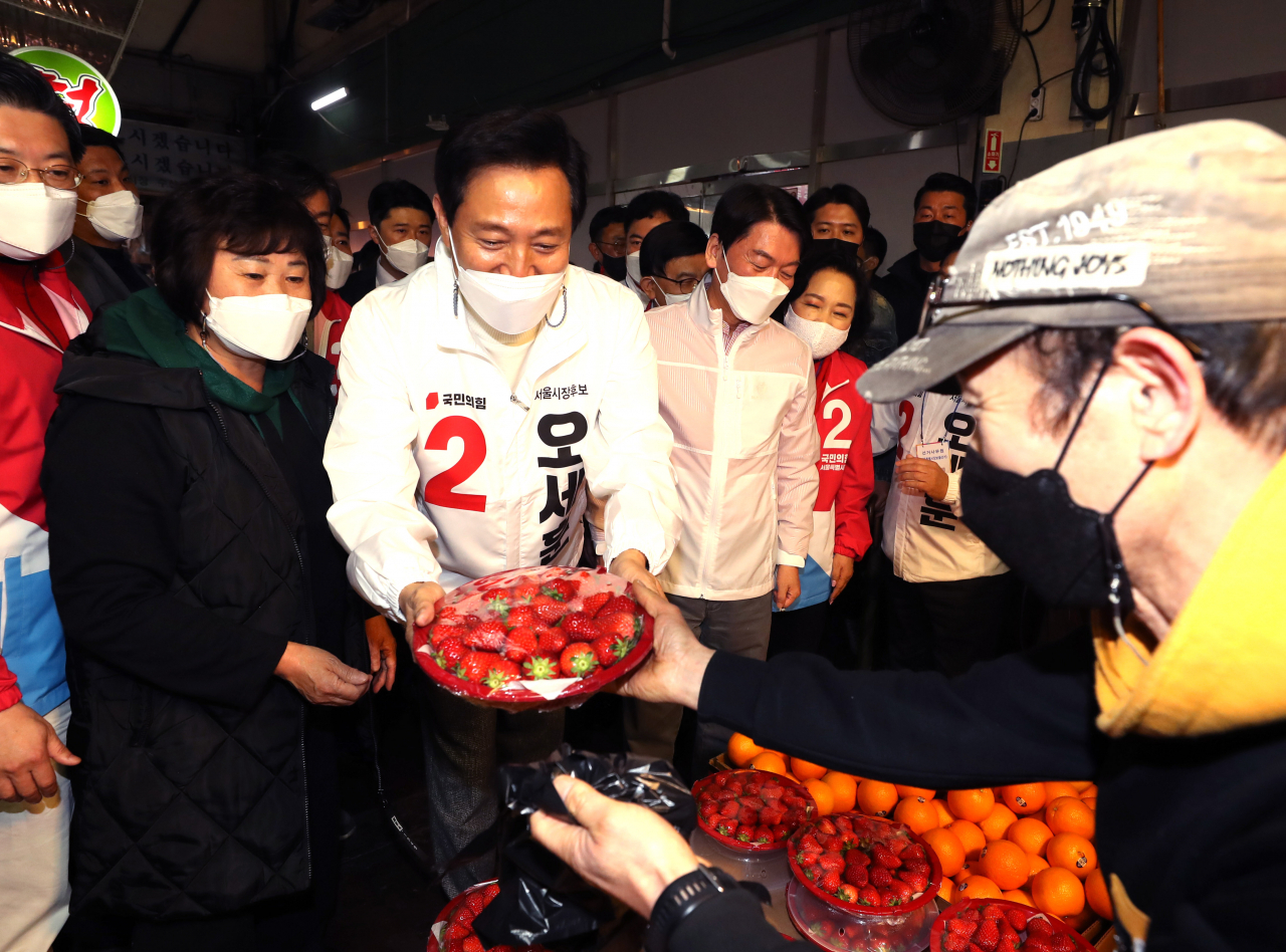국민의힘 오세훈 서울시장 후보(오른쪽)가 주말인 지난 27일 서울 마포농수산물시장에서 딸기를 구매하고 있다. 국회사진기자단