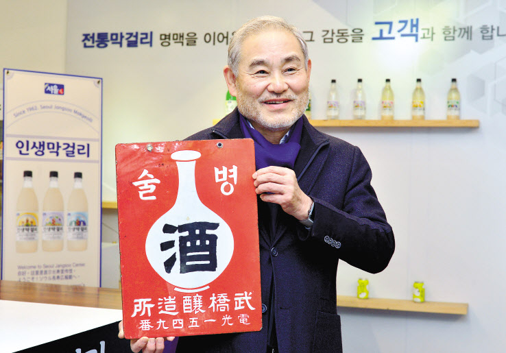유병창 서울탁주제조협회 영업본부 사장이 서울 망원동 소재 장수막걸리 홍보관에서 1910년대 서울 통의동 코오롱 사옥 자리에서 증조부가 운영하셨던 ‘무교 양조장’ 간판을 들고 기념촬영을 하고 있다. 사진=박현구 기자