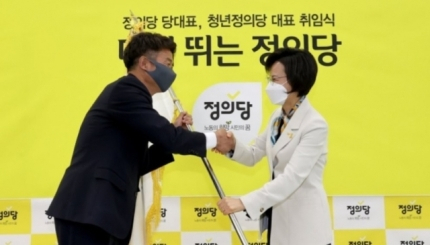 여영국 정의당 대표가 지난 24일 오전 서울 여의도 국회에서 열린 취임식에서 강은미 비상대책위원장으로부터 당기를 전달받고 있다.[이상섭 기자]