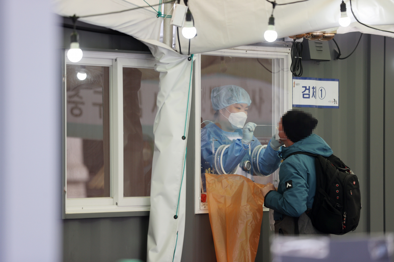 코로나19 신규 확진자가 384명 발생한 29일 오전 서울역에 마련된 임시선별진료소에서 의료진이 검체채취를 하고 있다. [연합]