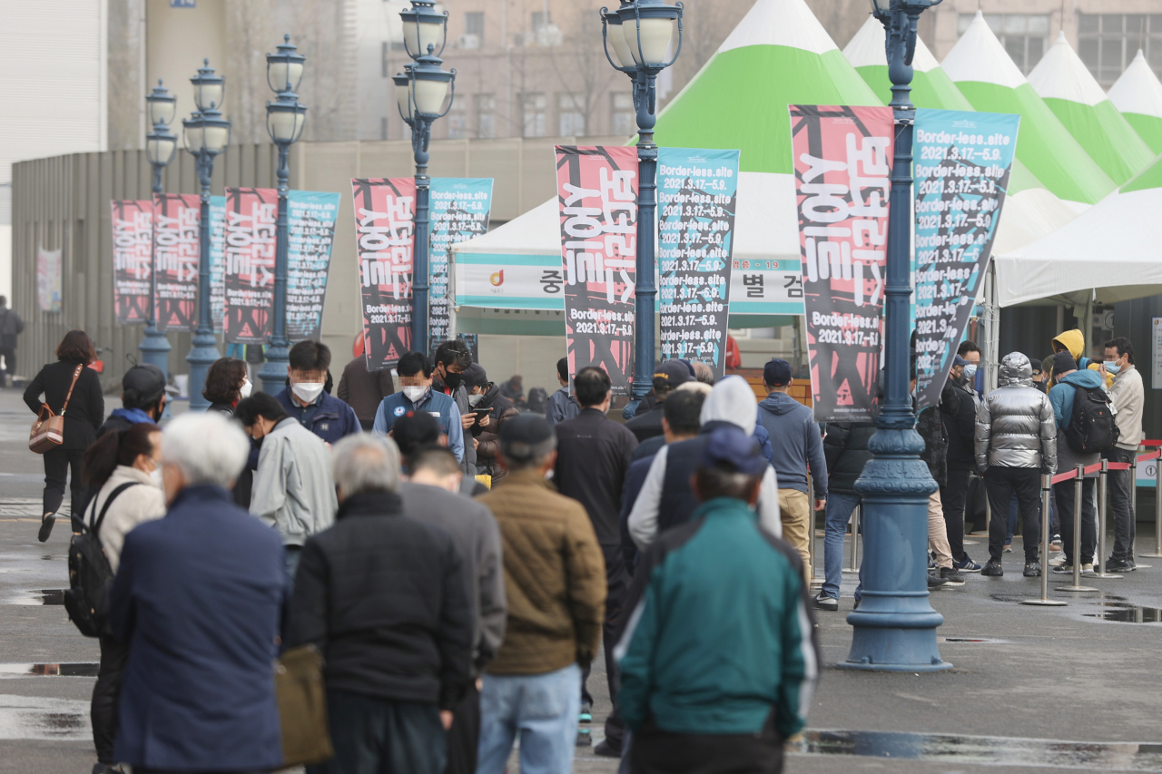 코로나19 신규 확진자가 384명 발생한 29일 오전 서울역에 마련된 임시선별진료소를 찾은 시민들이 검체 검사를 받기 위해 줄을 서 있다. [연합]