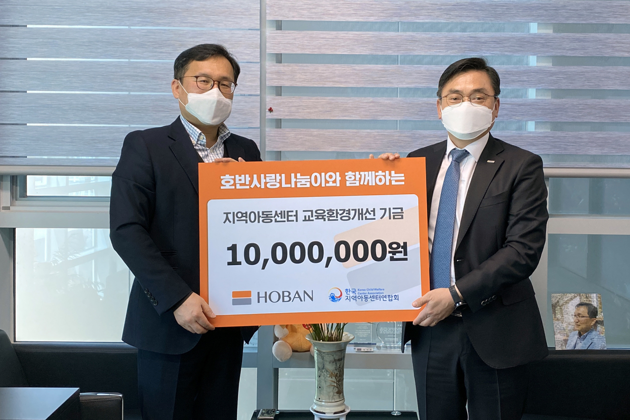 손달원 호반건설 상무(오른쪽)와 옥경원 한국지역아동센터연합회 대표가 30일 후원금을 전달한 뒤 기념촬영을 하고 있다. [호반건설 제공]