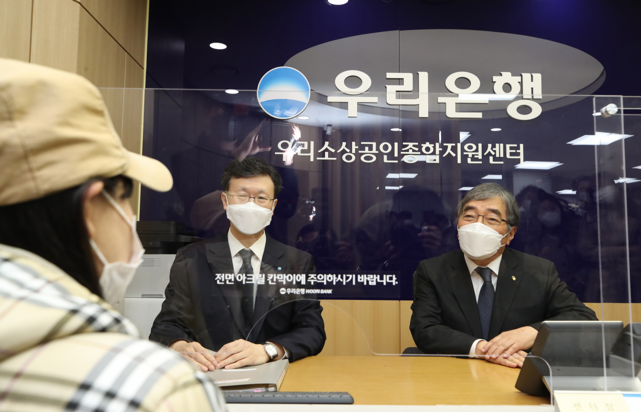 윤석헌 금융감독원장이 30일 오후 서울 강동구 우리은행 길동지점에 설치된 '우리은행 소상공인 종합지원 길동센터'를 찾아 소상공인과 상담하고 있다. 연합뉴스