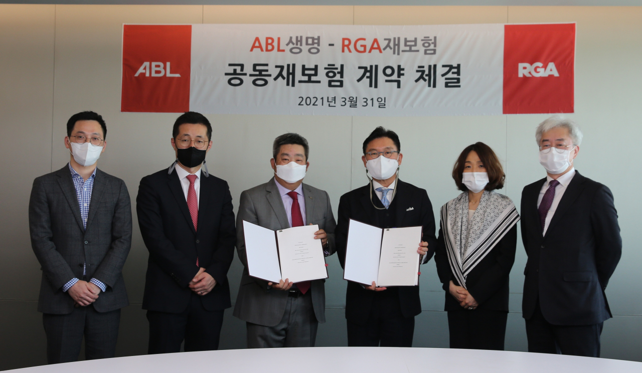 ABL생명이 31일 서울 여의도 본사에서 RGA재보험 한국지점과 공동재보험 계약을 체결하고 있다. 시예저치앙(왼쪽에서 세번째) ABL생명 사장과 RGA재보험 한국지점 신성욱(왼쪽에서 네번째) 사장이 양사 임직원들과 기념촬영을 하고 있다. [ABL생명]