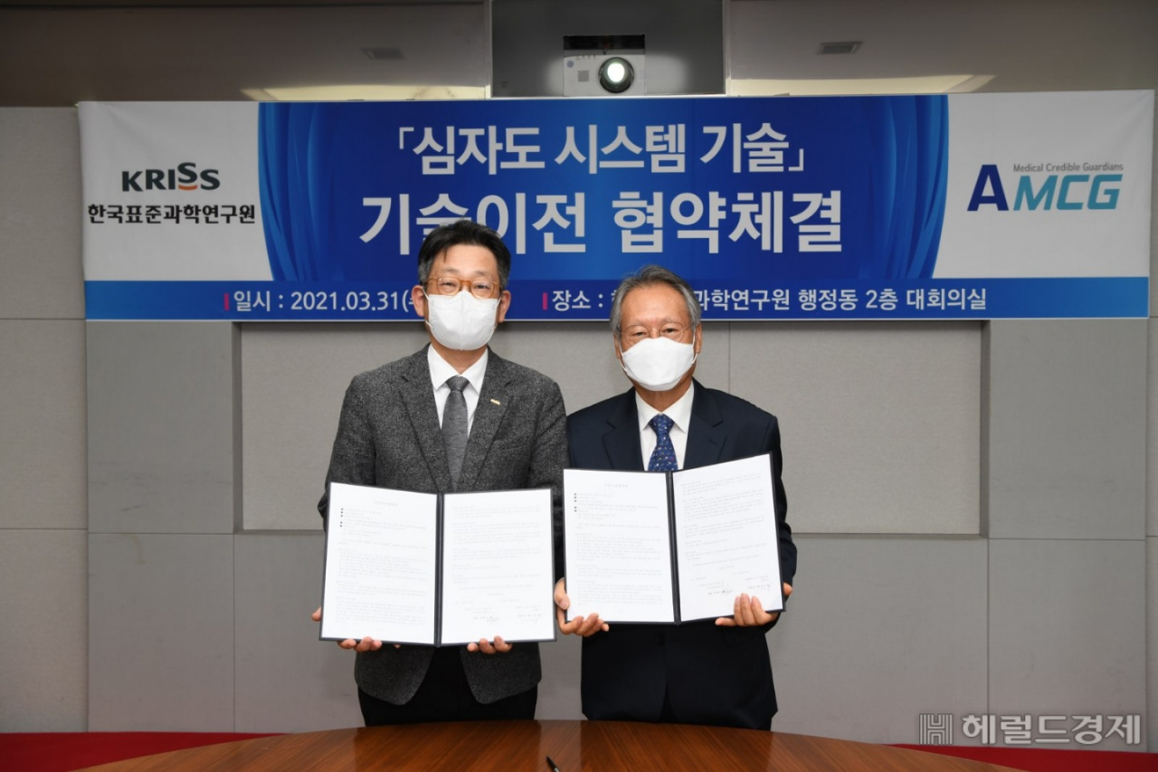 박현민(사진 왼쪽)한국표준과학연구원장과 한오석 ㈜AMCG 대표이사가 심장질환 진단장치인 심자도시스템 기술이전 협약을 체결한 뒤 기념 사진을 찍고 있다.