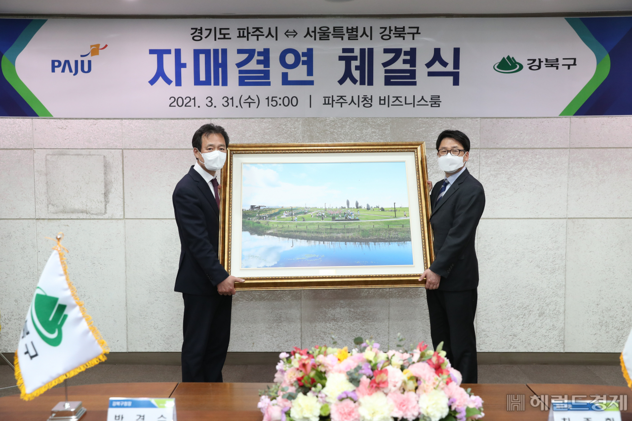 박겸수(왼쪽) 강북구청정과 최종환 파주시장이 자매결연 협약을 맺고 기념촬영을 하고 있다.[강북구 제공]