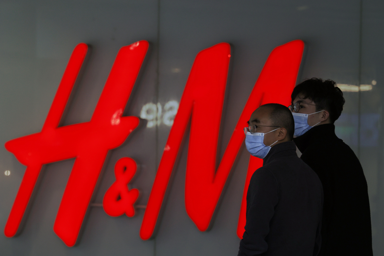 중국 베이징에서 쇼핑몰 방문객들이 의류 브랜드 H&M 옆을 지나가고 있다.[AP]