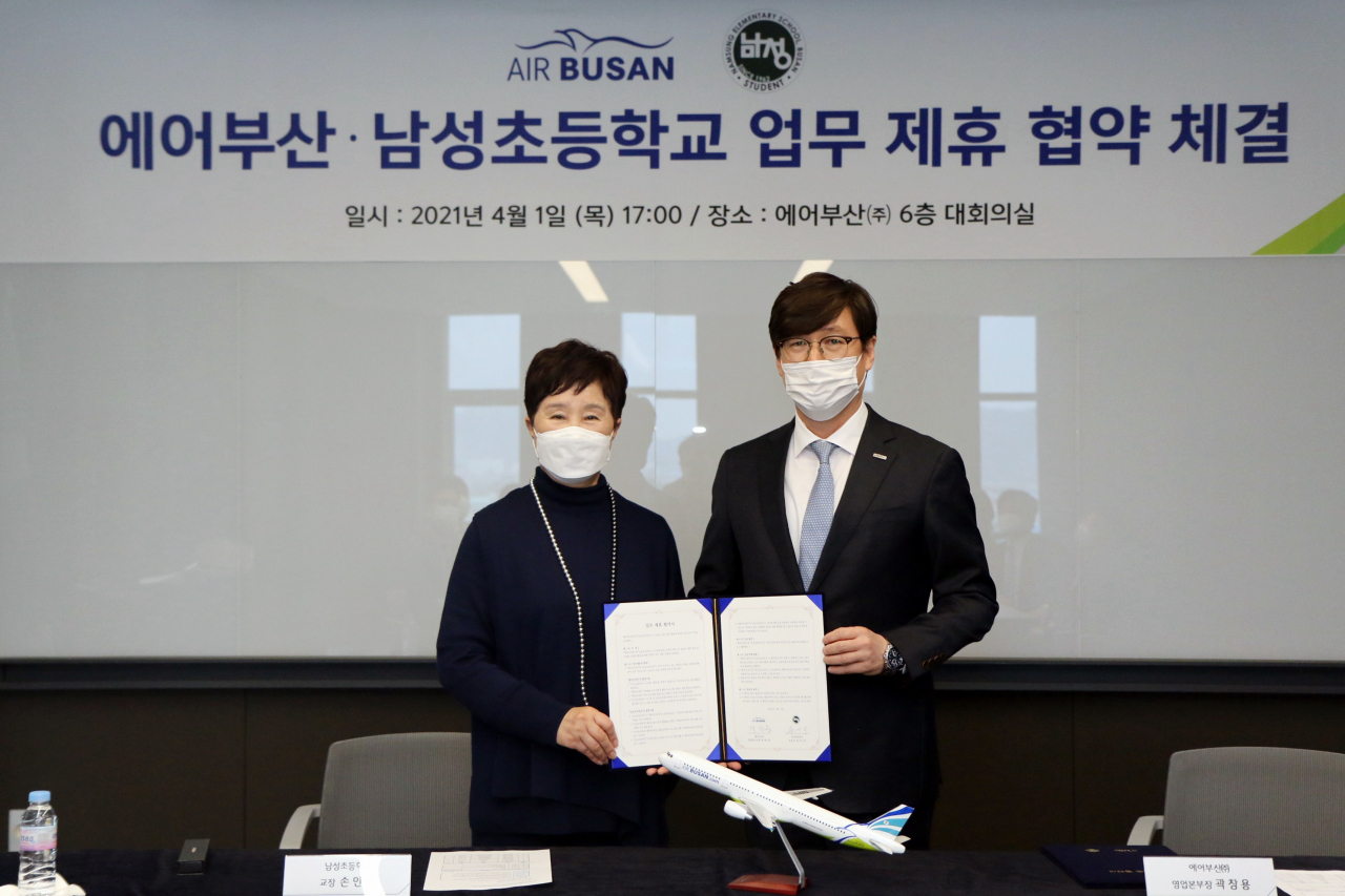 1일 오후 에어부산 본사에서 열린 에어부산과 부산 남성초등학교와의 업무 제휴 협약식에서 에어부산 곽창용 영업본부장(사진 우측)과 남성초등학교 손인숙 교장(좌측)이 업무 협약 체결 후 기념촬영을 하고 있다. [에어부산 제공]