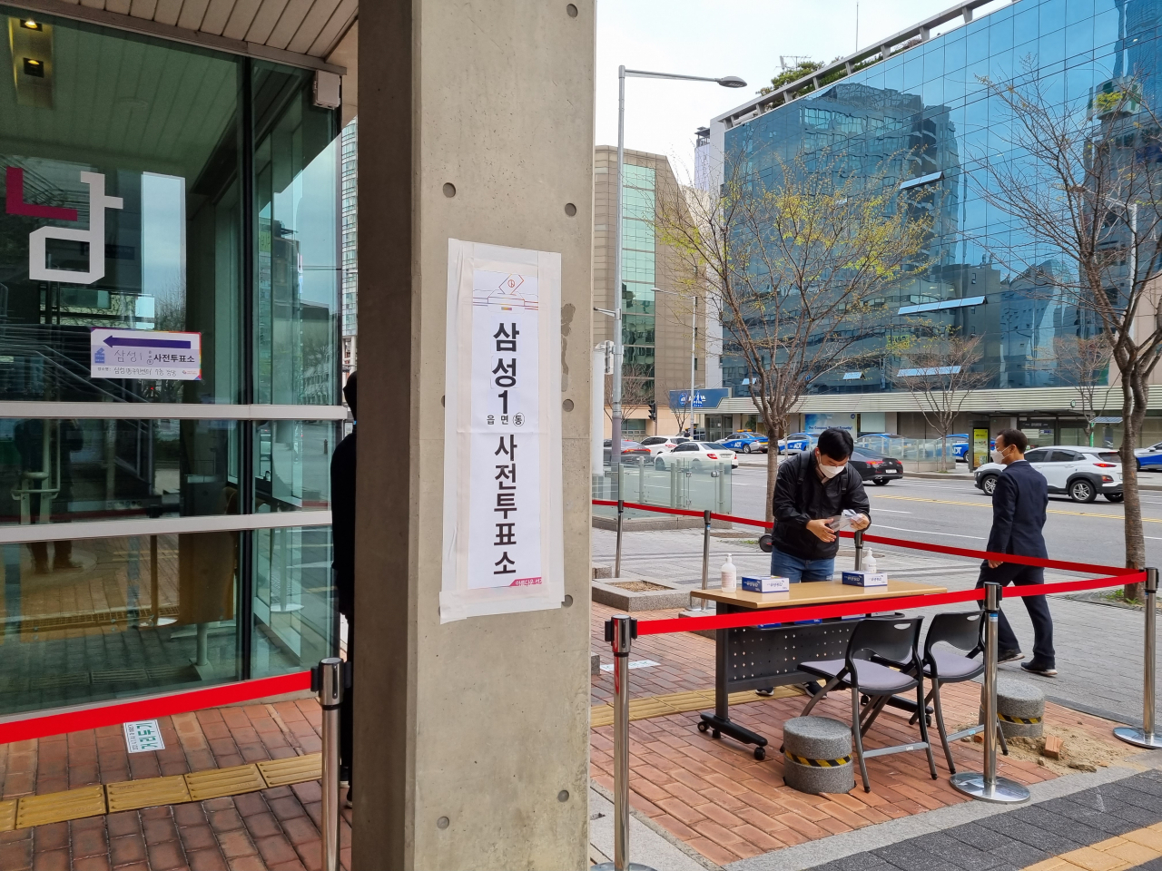 4·7 서울시장 재보궐선거 사전투표 첫날인 2일 오전 한 유권자가 삼성1동 사전투표소 앞에 마련된 방역 부스에 비치된 비닐장갑을 착용하고 있다.