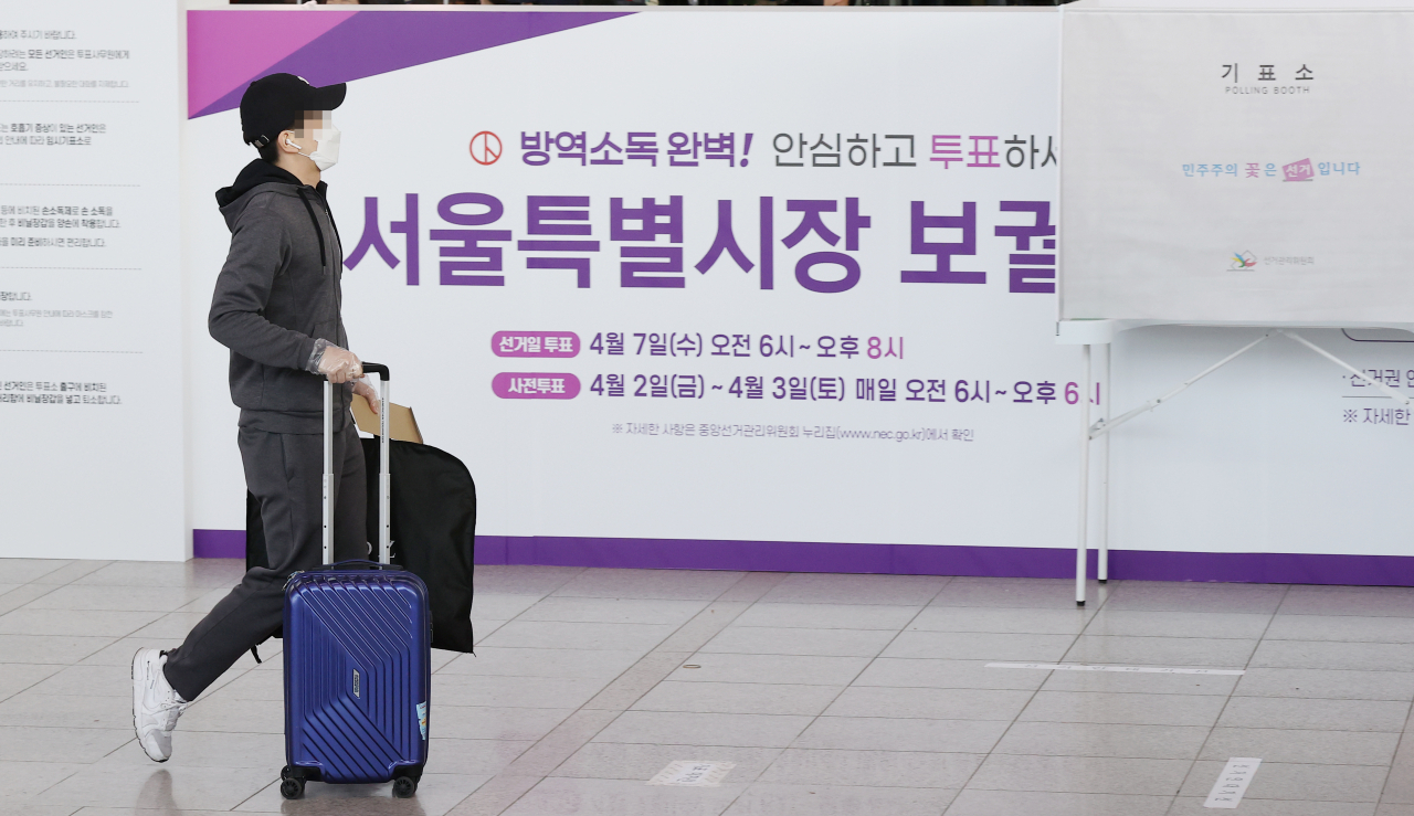 4·7 재·보궐선거 사전투표 첫날인 2일 오전 서울역에 설치된 남영동 사전투표소에서 한 시민이 캐리어를 끌고 기표소로 향하고 있다. 사전투표는 2~3일 이틀 동안 오전 6시부터 오후 6시까지 진행된다. [연합]