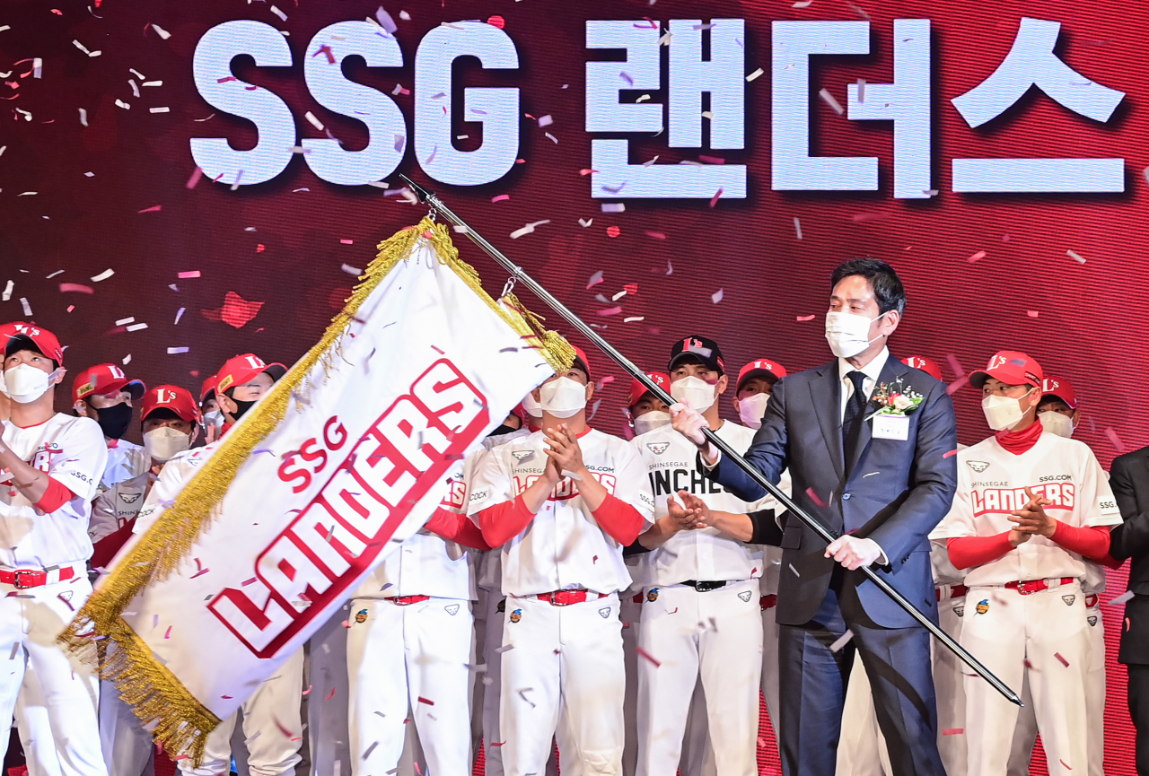 30일 오후 서울 중구 웨스틴 조선호텔에서 열린 SSG 창단식에서 구단주인 정용진 신세계 부회장이 정지택 KBO 총재에게 구단기를 전달받은 뒤 흔들고 있다. [연합]