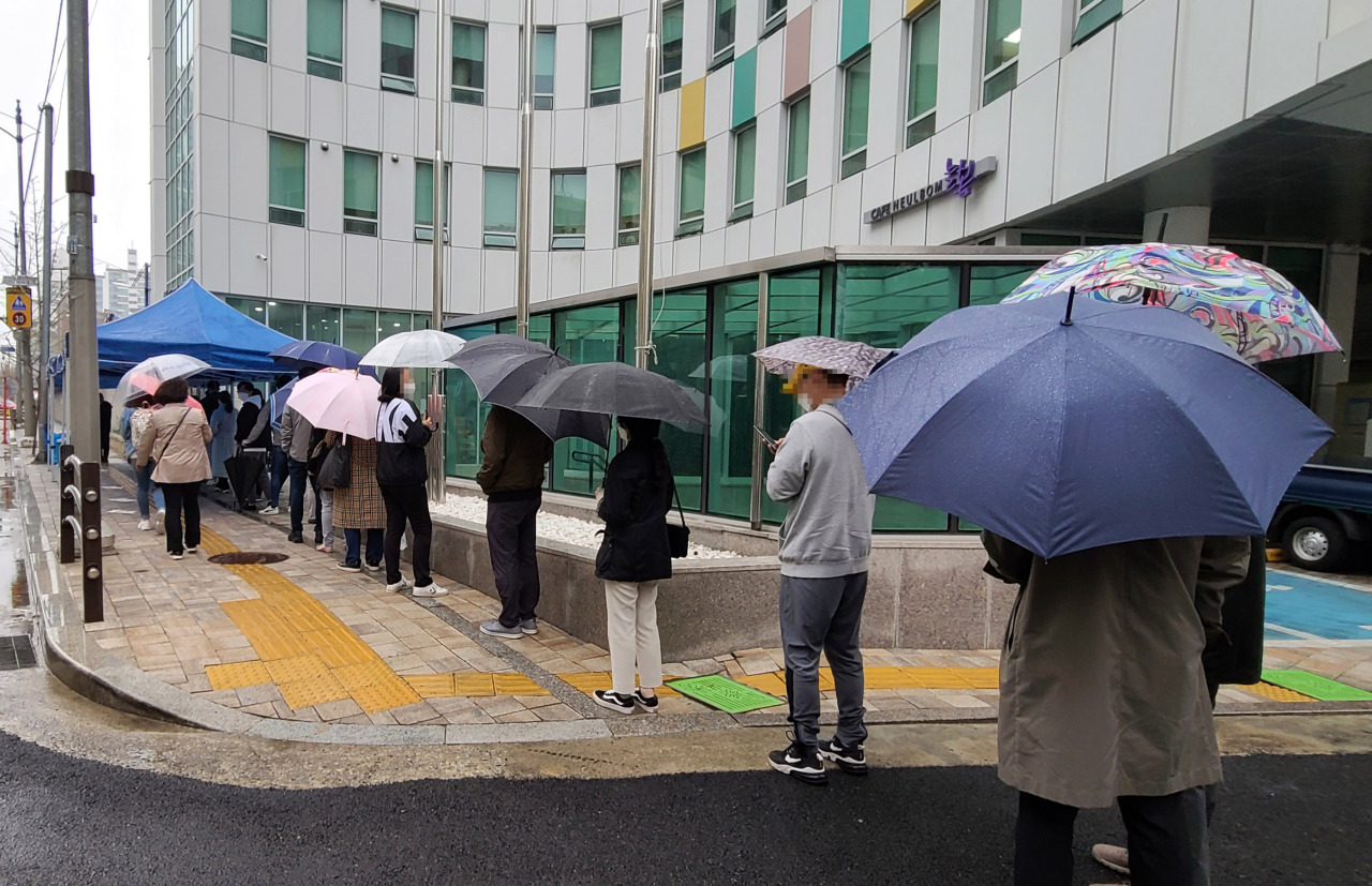 Voters wait in line Saturday afternoon to cast their ballots for the by-election for Seoul mayor at a early voting center in Seocho-gu, southern Seoul. (Yonhap)