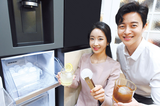 모델이 칵테일, 위스키, 레모네이드, 아이스커피 등 시원한 음료를 집에서도 제대로 즐길 수 있게 해주며 음료의 풍미를 더해주는 지름 약 50밀리미터(mm)의 구형 얼음인 크래프트 아이스(Craft Ice)를 소개하고 있다. [LG전자 제공]