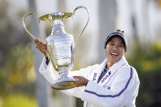 태국 신인 패티 타와타나낏이 5일(한국시간) LPGA 투어 시즌 첫 메이저 ANA 인스퍼레이션 정상에 올라 포피스 폰드에 빠지는 우승 세리머니를 펼친 뒤 우승컵을 들고 환하게 웃고 있다. [AP]