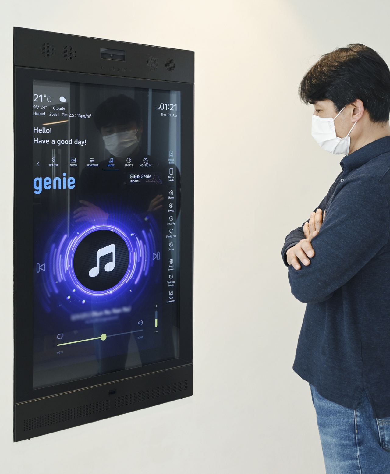 LG전자 직원이 KT 기가지니 인공지능(AI) 기술이 적용된 LG 스마트미러를 활용해 지니뮤직 음악감상 서비스를 실행하고 있다. [KT제공]