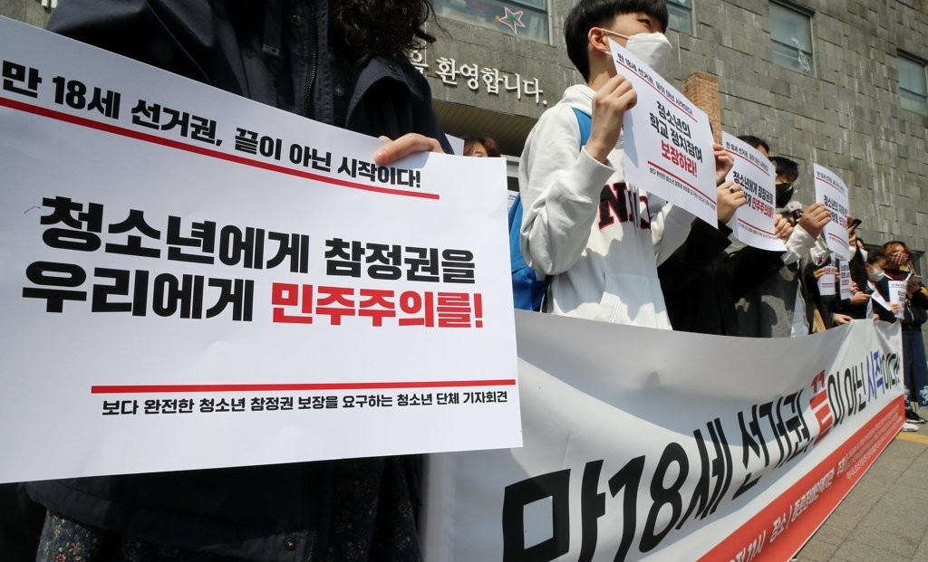 지난해 4월 11일 서울 마포구 서교동주민센터에 마련된 사전투표소 앞에서 시민단체인 청소년 인권행동 아수나로 관계자들이 “나이에 의한 선거권 제한 자체를 폐지해야 한다”고 주장하며 손 팻말을 들고 있다. [연합]