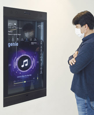LG전자 직원이 KT 기가지니 인공지능(AI) 기술이 적용된 LG 스마트미러를 활용해 지니뮤직 음악감상 서비스를 실행하고 있다. [KT제공]
