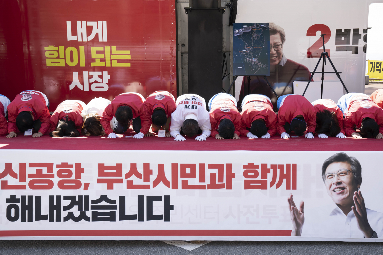 박형준 국민의힘 부산시장 후보(가운데 하얀색 점퍼)가 부산 선대위와 6일 가덕신공항 부지에서 현장 결의대회를 진행하며 큰절을 하고 있다. [박형준 캠프 제공]