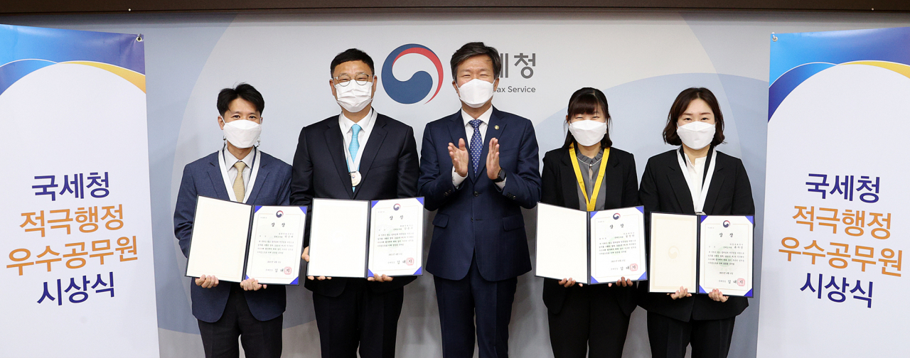 김대지(가운데) 국세청장이 6일 ‘2021년 1차 적극행정 우수공무원’에 선정된 직원들과 기념촬영을 하고 있다. [국세정 제공]