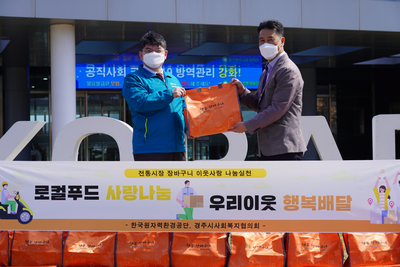 차성수 한국원자력환경공단 이사장(왼쪽)이 김종우 경주시사회복지협의회장에게 행복장바구니를 전달하고 있다.[한국원자력환경공단 제공]