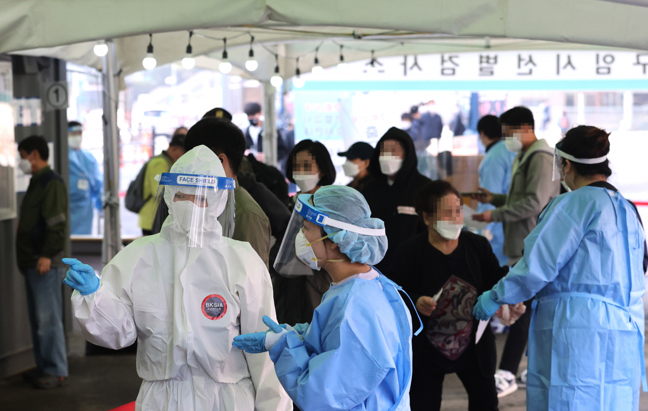 코로나19 신규 확진자 수가 668명을 기록한 7일 오전 서울역 코로나19 임시선별검사소에서 의료진이 대화를 나누고 있다. [연합]