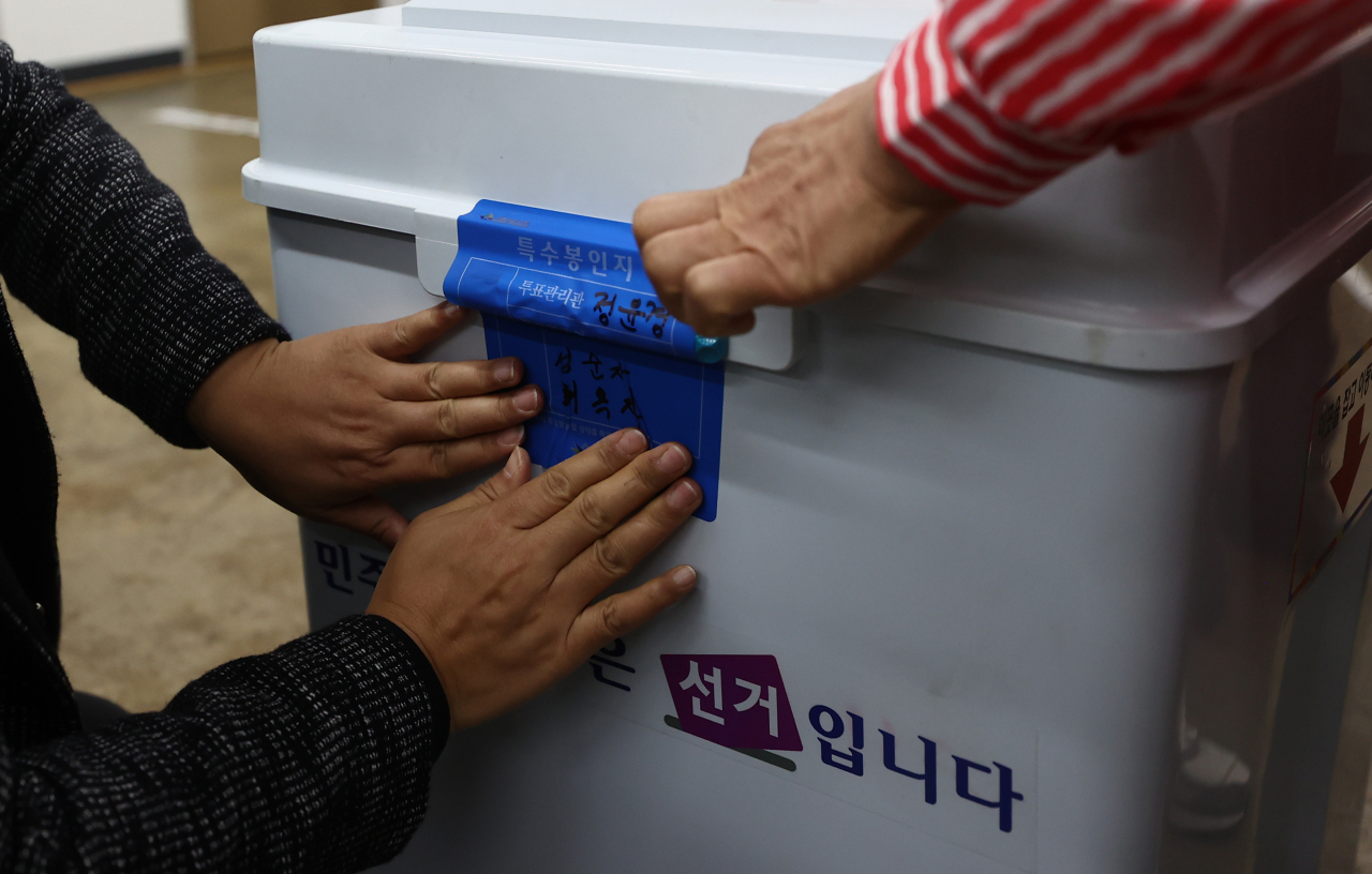 서울시장 보궐선거일인 7일 오전 서울 노원구 중계본동 제3투표소에서 선거관리위원회 관계자와 투표참관인들이 투표함 봉인 작업을 하고 있다. [연합]