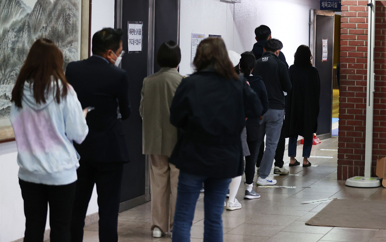 2021 재·보궐선거 투표일인 7일 저녁 서울 강남구 단국대학교 사범대학 부속고등학교 체육관에 마련된 대치1동 제1투표소를 찾은 시민들이 투표를 하기 위해 줄을 서 있다. [연합]