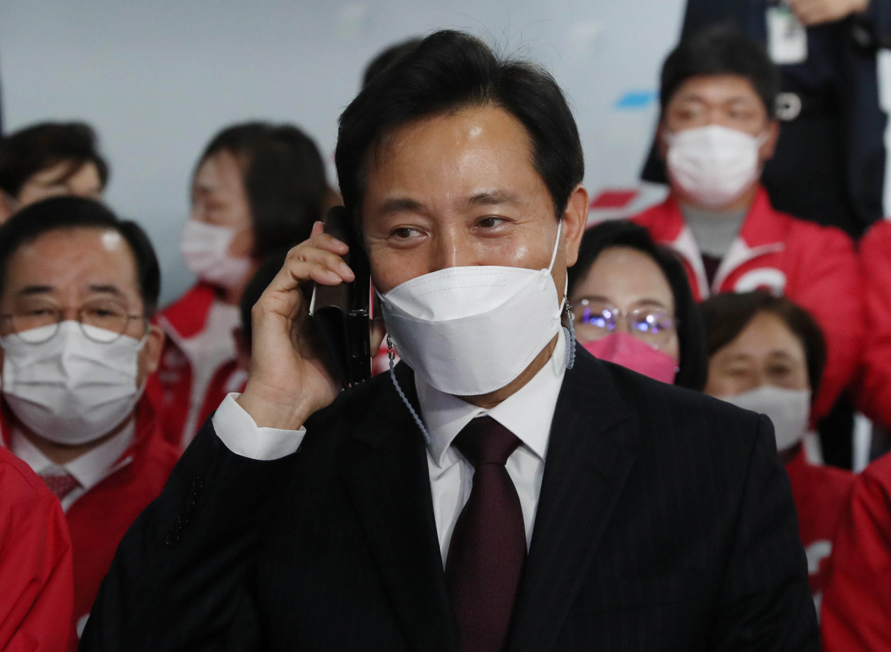 국민의힘 오세훈 서울시장 후보가 7일 서울 여의도 국민의힘 중앙당사 개표상황실에서 방송3사(KBS,MBC,SBS) 공동 출구 조사 결과발표를 지켜보며 전화통화를 하고 있다. [연합]