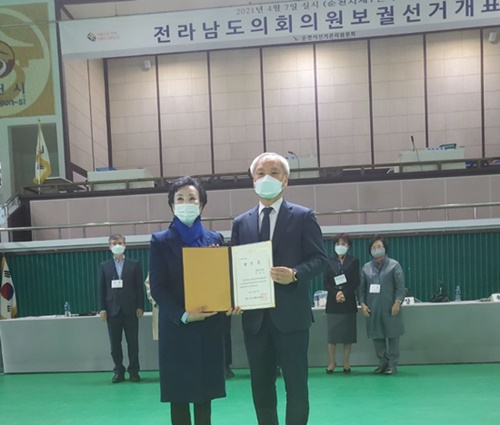 전남도의원 순천1선거구 보궐선거에서 당선된 한춘옥 후보(왼쪽)가 선관위로부터 당선증을 받고 있다. [민주당 제공]