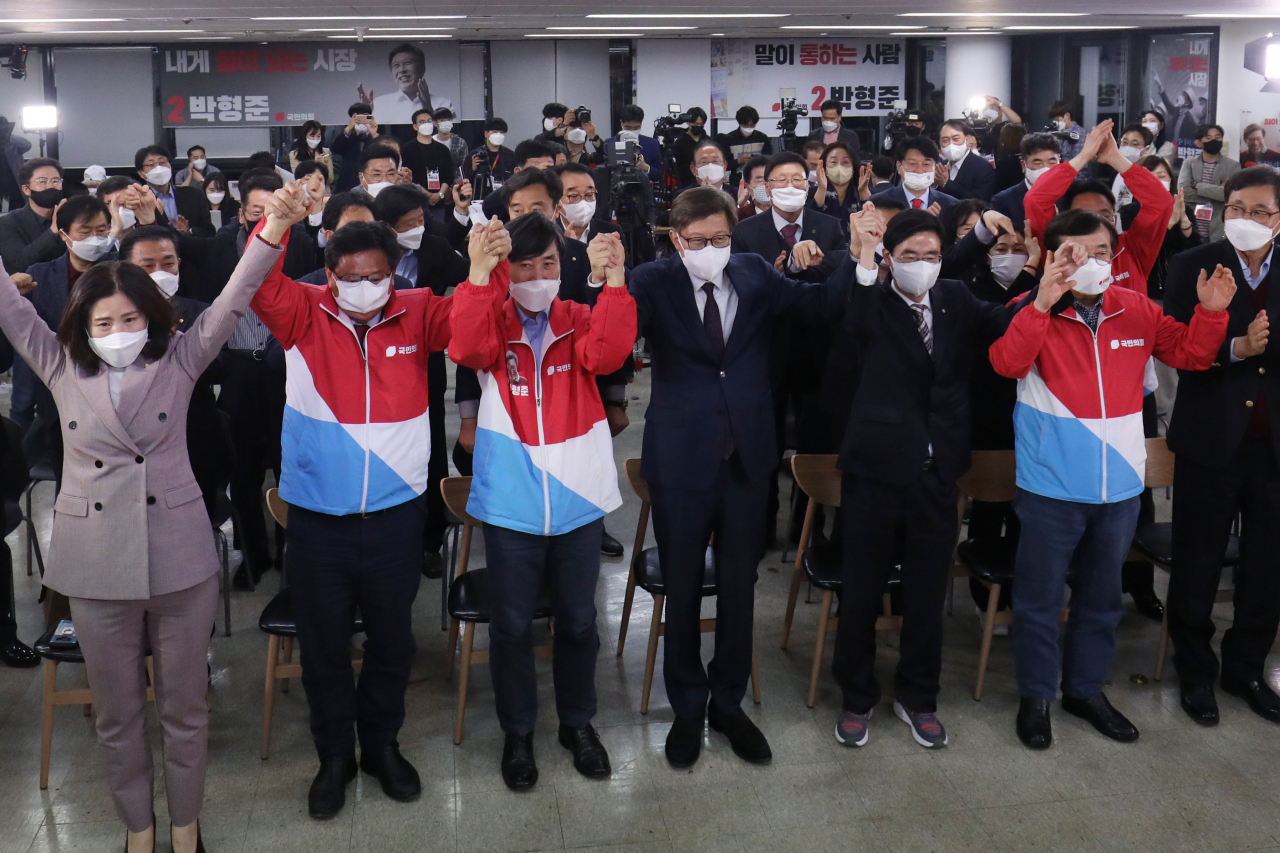 박형준 국민의힘 부산시장 후보가 7일 오후 부산진구 선거사무소에서 출구조사 결과가 발표되자 의원들과 손을 맞잡고 있다. [연합]