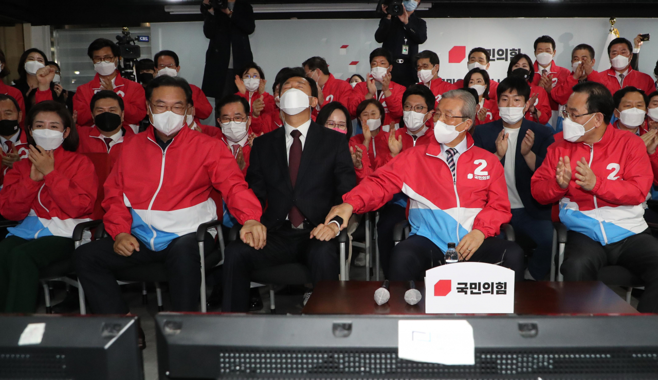 오세훈 국민의힘 서울시장 후보(앞줄 가운데)가 7일 서울 여의도 국민의힘 중앙당사 개표상황실에서 방송3사(KBS,MBC,SBS) 공동 출구 조사 결과발표에서 더불어민주당 박영선 서울시장 후보를 크게 앞서는 걸로 예측되자 김종인 비상대책위원장(오 후보 오른쪽), 정진석 의원(오 후보 왼쪽) 등과 기뻐하고 있다. [국회사진기자단]