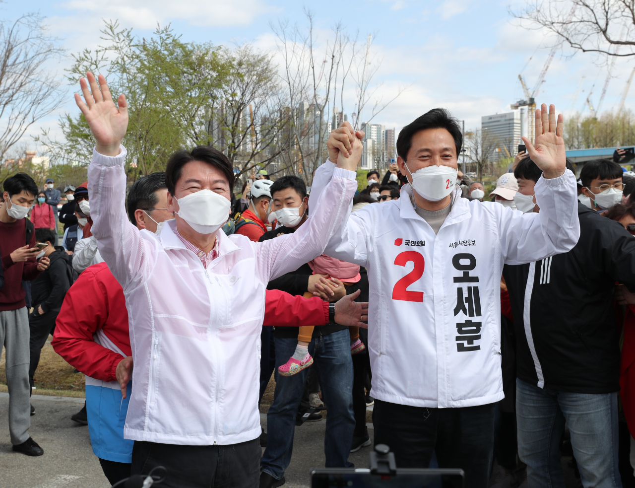 오세훈 국민의힘 서울시장 후보(오른쪽)와 안철수 국민의당 대표가 지난 4일 오후 서울 서초구 세빛섬 인근 한강공원에서 열린 '시민과 함께 걷기' 행사에서 시민들에게 인사하고 있다. [국회사진기자단]